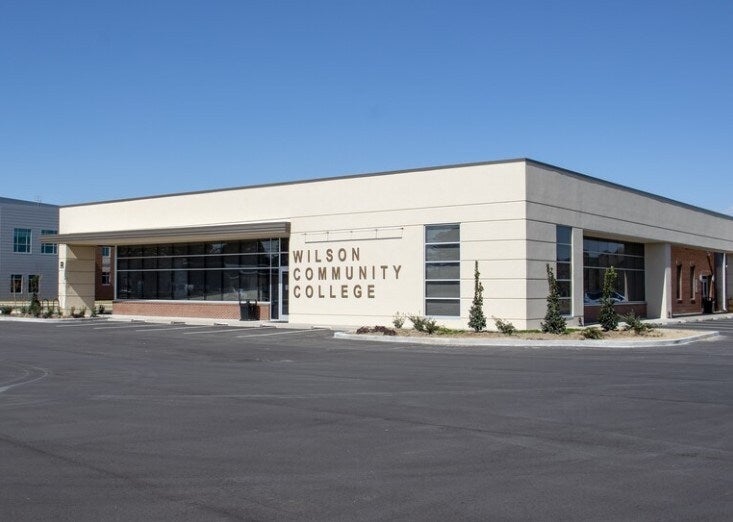 Exterior of the modern Wilson Community College building, a light-colored structure with large dark windows.